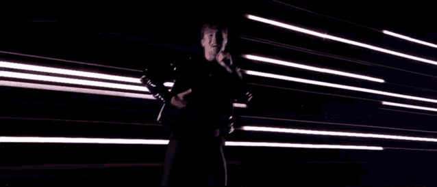 a man is dancing in front of a wall of white lights