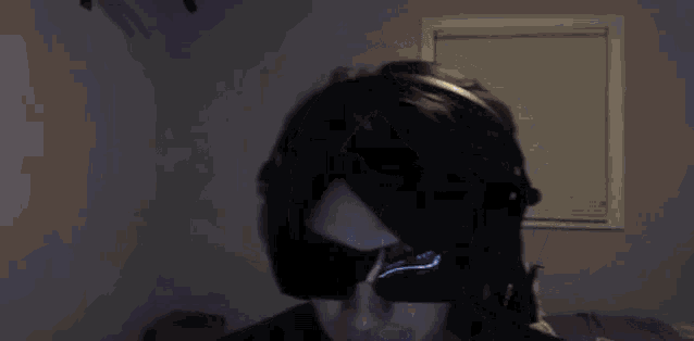 a man wearing headphones is playing a video game on a computer .