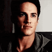 a close up of a man 's face in a dark room looking at the camera .
