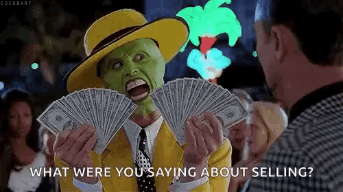 a man with a mask on his face is holding a fan of money and asking what were you saying about selling .