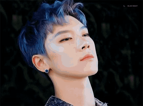 a close up of a person 's face with blue hair .
