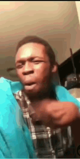 a man in a blue shirt and plaid shirt is making a face