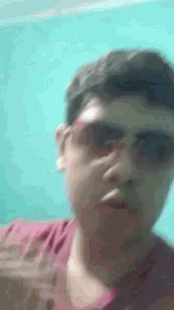 a man wearing sunglasses is making a funny face while smoking a cigarette .
