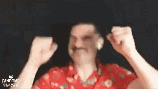 a man with a mustache is making a funny face while wearing headphones and a red shirt .