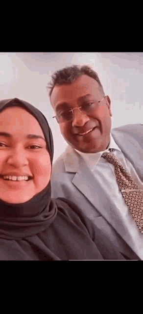 a man and a woman are posing for a picture together and smiling .