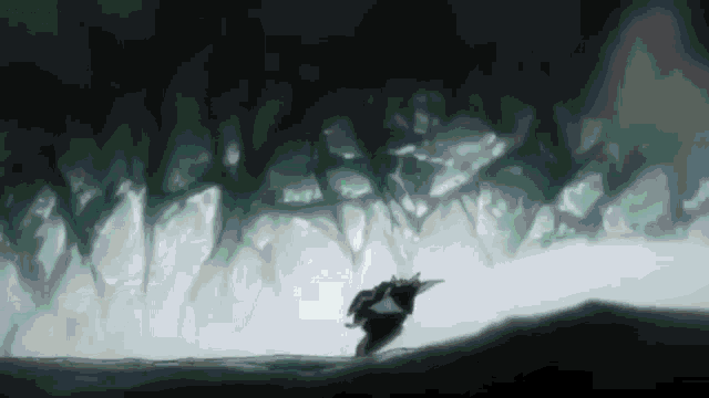 a person is walking through a dark forest with trees in the background
