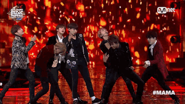 a group of young men are performing on a stage with the hashtag mama