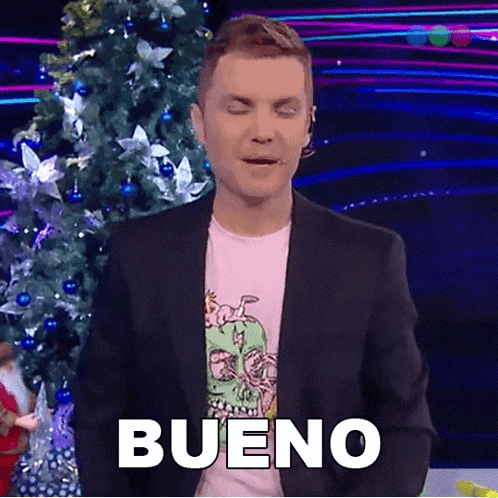 a man in a suit and a pink shirt says bueno