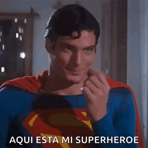 a man in a superman costume is giving the middle finger and says aqui esta mi superheroe .