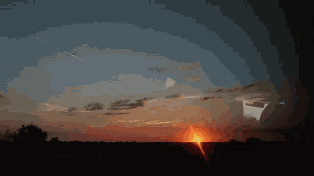 a sunset with a few clouds and a few stars