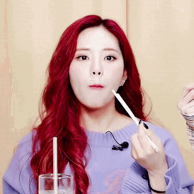 a girl with red hair is eating with chopsticks