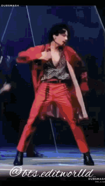 a man in red pants is dancing on a stage