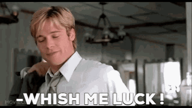 a man in a white shirt and tie is standing in a room and saying `` whish me luck '' .