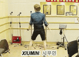 a man standing in front of a microphone with the name xiumin on the bottom