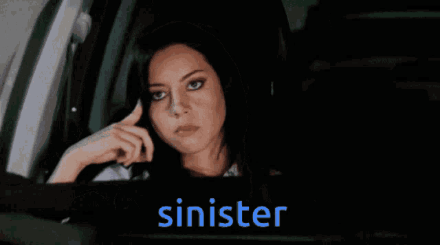 a woman in a car with the word ' sinister ' behind her