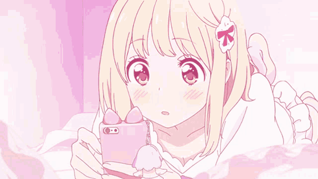 a girl laying on a bed looking at a cell phone