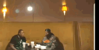 two men are sitting at a table in a restaurant