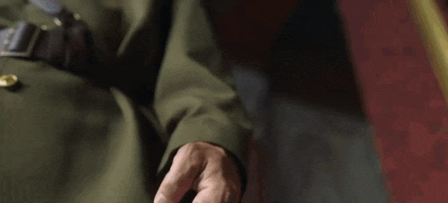 a close up of a person holding a gun in a dark room