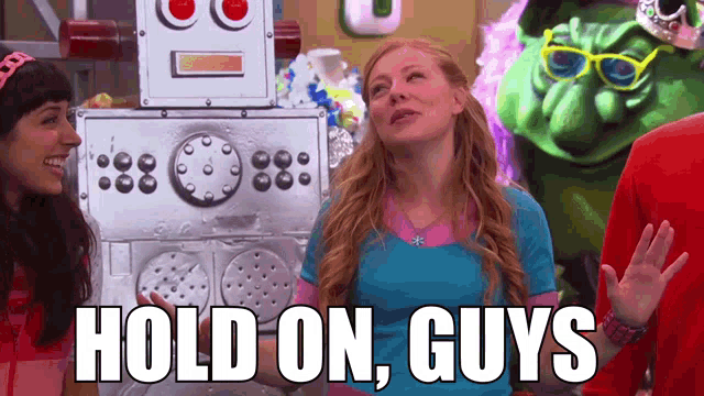 a woman stands in front of a robot with the words hold on guys on the bottom