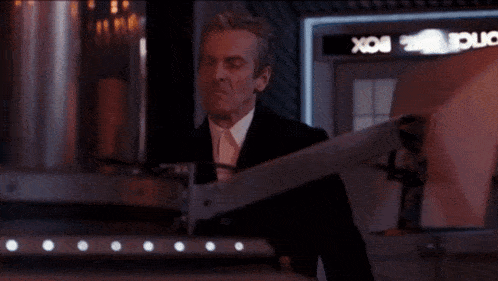 a man in a suit is standing in front of a box that says box on it