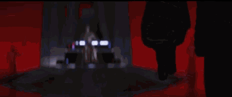a person is holding a light saber in their hand in a room .