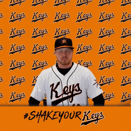 a man wearing a keys jersey stands in front of an orange wall
