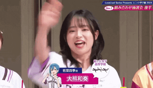 a girl with chinese writing on her shirt is raising her hand in the air .