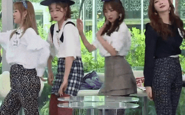 a group of young women are standing next to each other in a room and dancing .