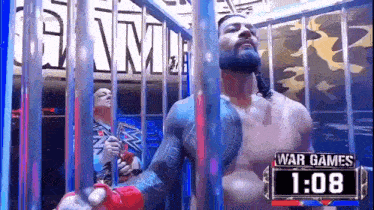 roman reigns is standing in a cage with a sign that says war games 1:08 .