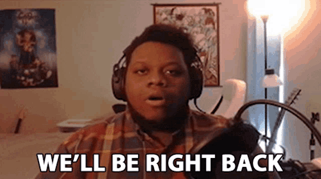 a man wearing headphones is saying `` we 'll be right back '' .