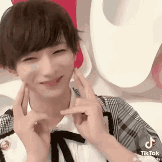 a young man is making a peace sign with his hands .