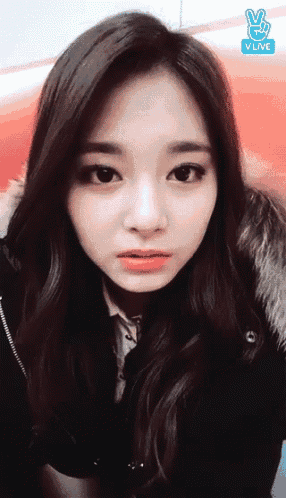 a close up of a woman 's face with a vlive logo on the bottom right