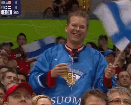 a man holding a flag and a beer in front of a crowd
