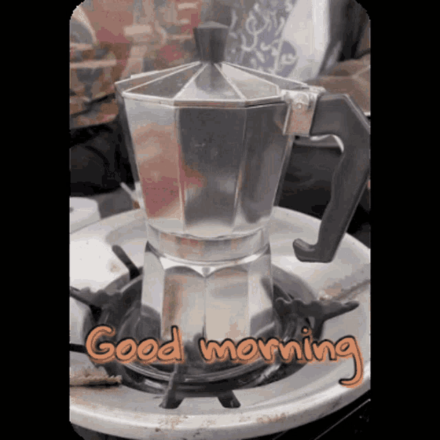 a coffee pot is sitting on a stove with the words " good morning " below it