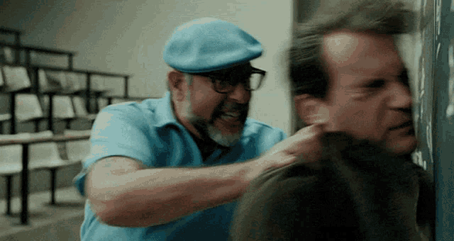a man wearing a blue hat and glasses is holding another man