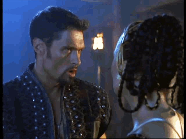 a man and a woman are standing next to each other and looking at each other