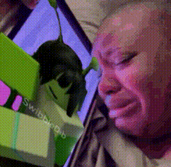 a man is crying while looking at a picture of shrek on a phone