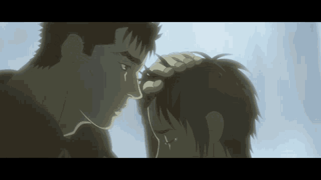 a man holds another man 's head with his hands