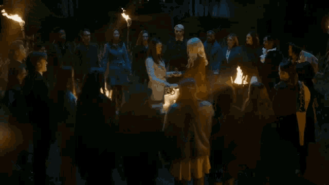 a group of people are standing in a circle with a person in the middle