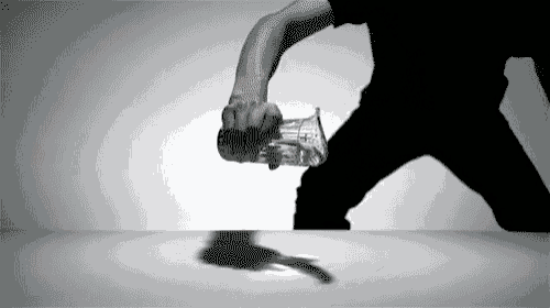 a man in a black shirt is holding a glass with the word coca cola on it