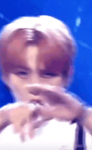 a blurry image of a person covering their face with their hands