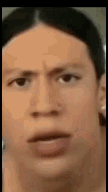 a close up of a man 's face with a serious expression .