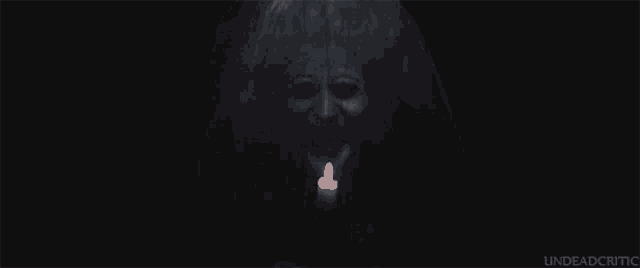 a woman is holding a candle in her mouth and the words " undeadcritic " are below her