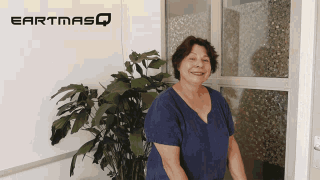 a woman stands in front of an earthmasq sign