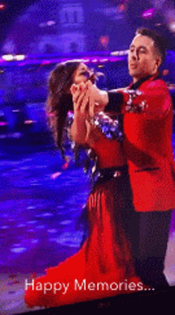 a woman in a red dress is dancing on a stage with the words happy memories behind her