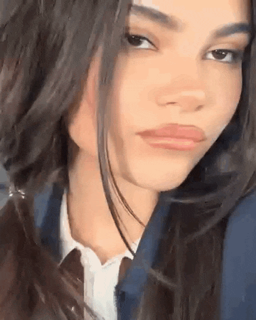 a close up of a woman 's face wearing a tie and a jacket .