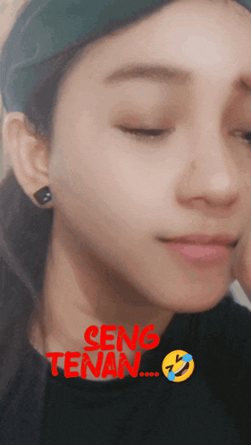 a close up of a woman 's face with the words seng tenan written on the bottom