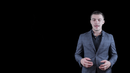 a man in a suit stands in front of a black background that says happy birthday