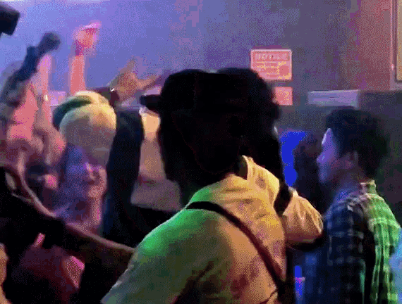 a group of people are dancing in front of a sign that says " notice "