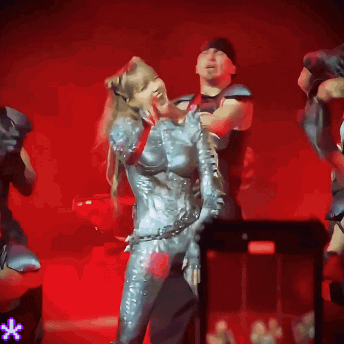 a woman in a silver costume is dancing on stage